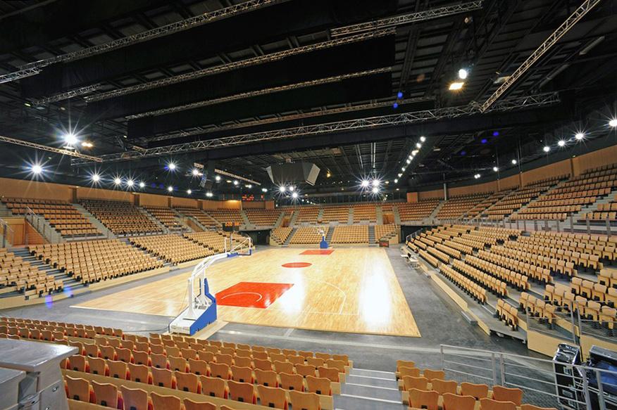 Große Sporthalle mit ausgefahrenen Teleskoptribünen rund um das Basketballfeld