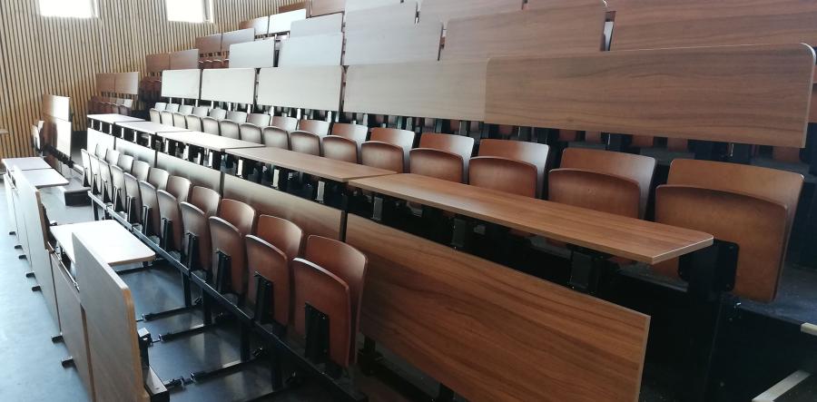 Hörsaal einer Berufsschule mit Holzsitzen und Schreibtablaren