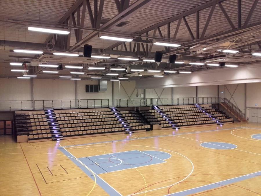 Handballhalle mit Teleskoptribüne und beleuchteten Treppen auf Sportboden