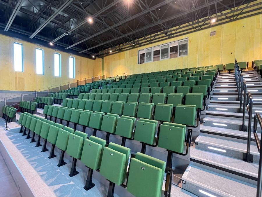 Schul-Auditorium mit grünen Polstersitzen auf Teleskoptribüne