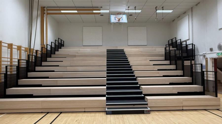 Teleskoptribüne mit Holz-Sitzstufen in einer Schulsporthalle