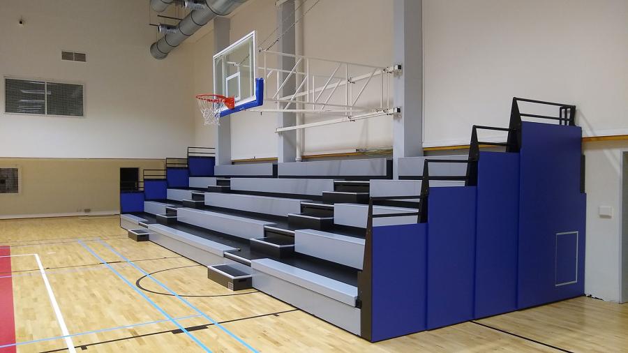 Ausgefahrene Tribüne mit klappbaren Geländern in einer Sporthalle
