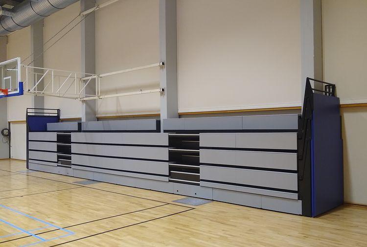 Eingefahrene Tribüne an der Wand einer Sporthalle