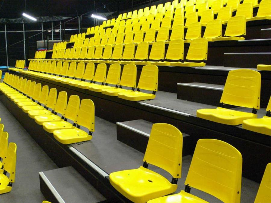 Gelbe Kunststoff-Sitzschalen auf einer Teleskoptribüne