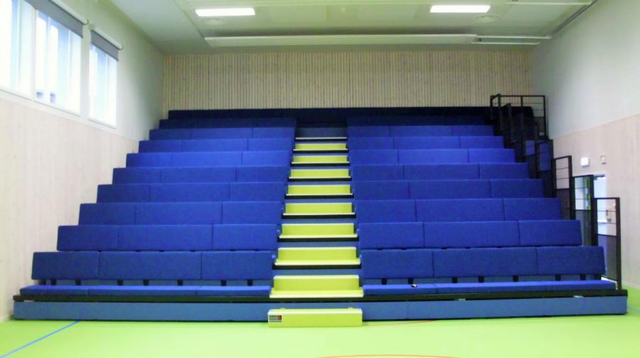 Teleskoptribüne mit blauen Sitzbänken und gelben Treppenstufen